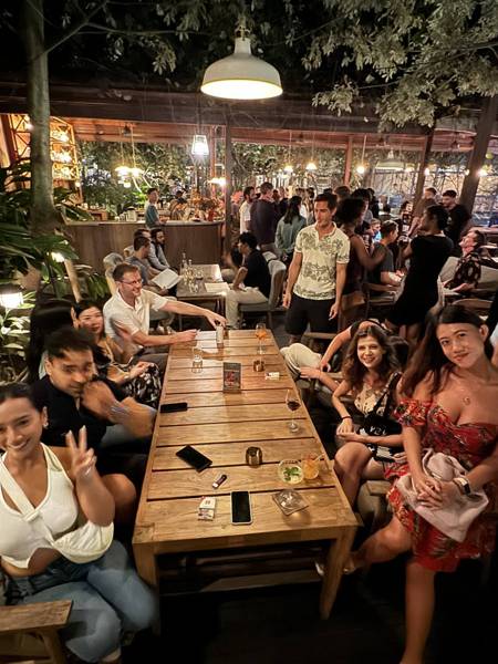 A group around a long wooden table, smiling for the camera