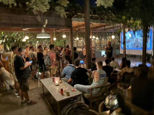 A garden full of people watching a talk