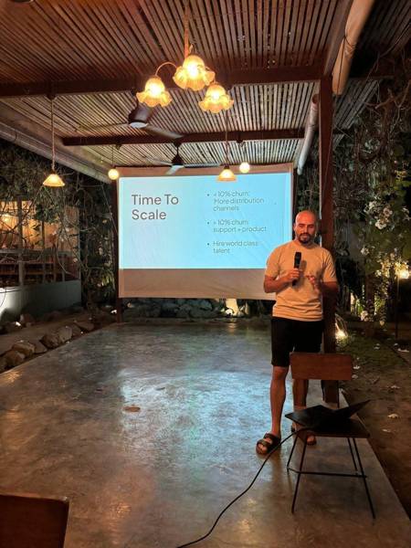 A speaker presenting a slide titled Time to Scale